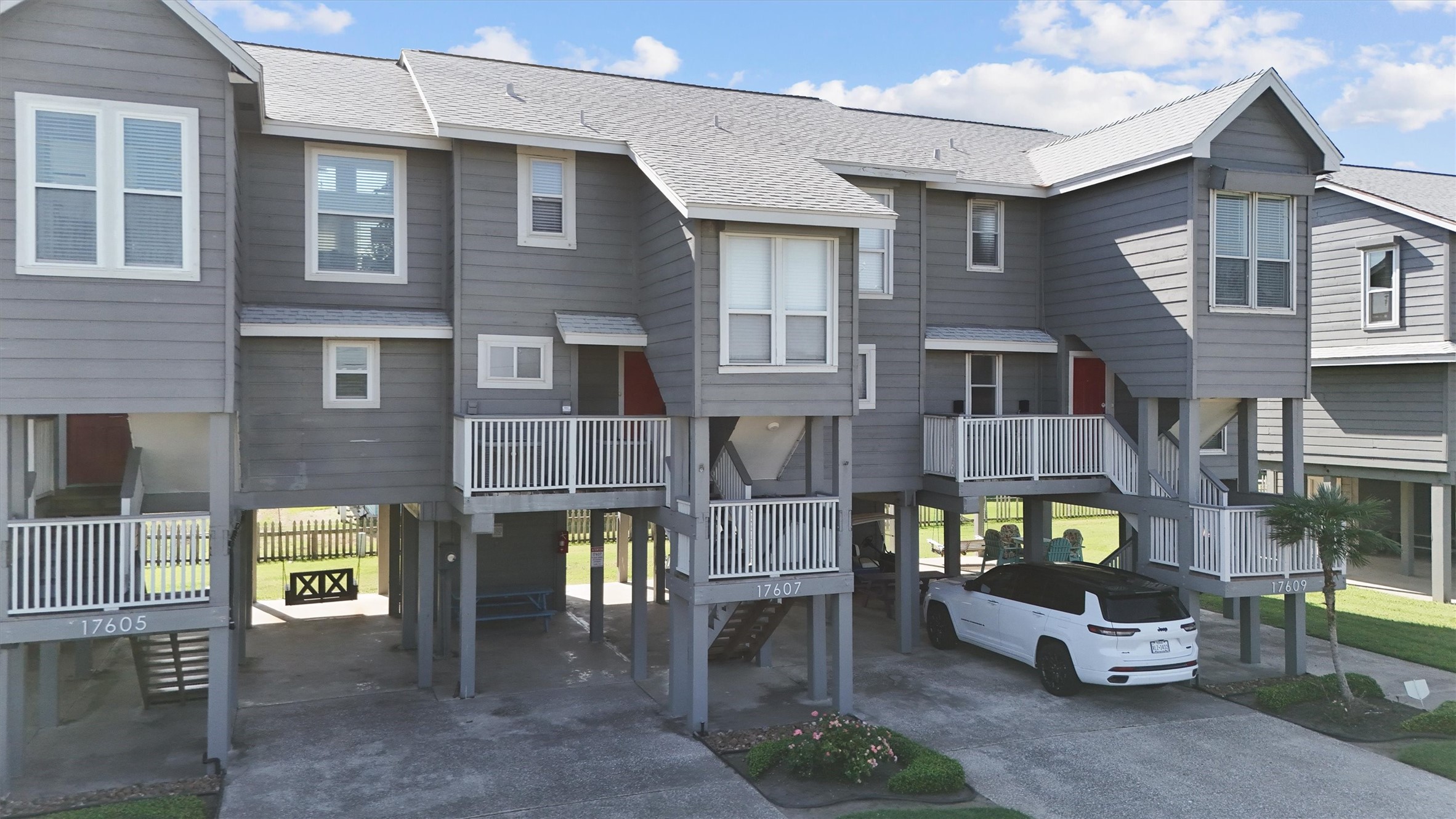 17607 Termini-San Luis Pass Road Galveston, TX 77554 - Photo 38 of 42 Featuring charming balconies and elevated entrances, this townhome captures the essence of coastal living. The front exterior is well-kept, offering a welcoming feel with easy accessibility.
