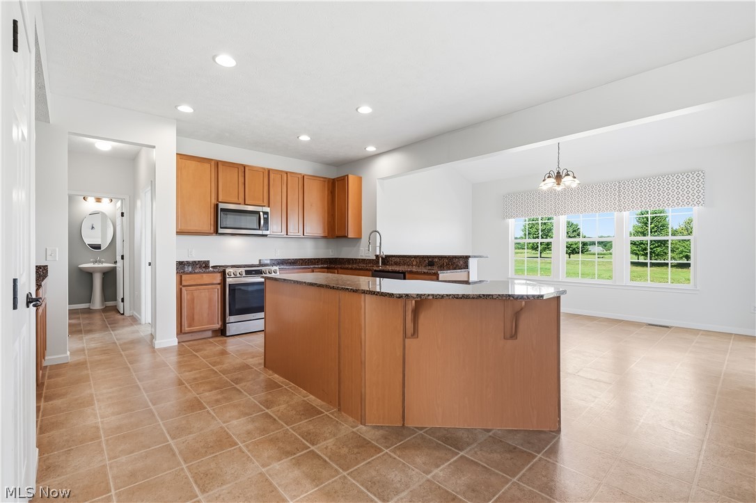 3280 Seven Bridges Road Medina, OH 44256 - Photo 12 of 41 Kitchen featuring light wood cabinetry, stone-finish countertops, stainless steel appliances, and tile flooring