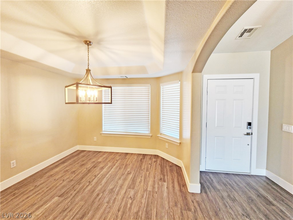 4591 Stoneham Street Pahrump, NV 89061 - Photo 10 of 42 A striking tray ceiling and a modern chandelier define this inviting dining space.