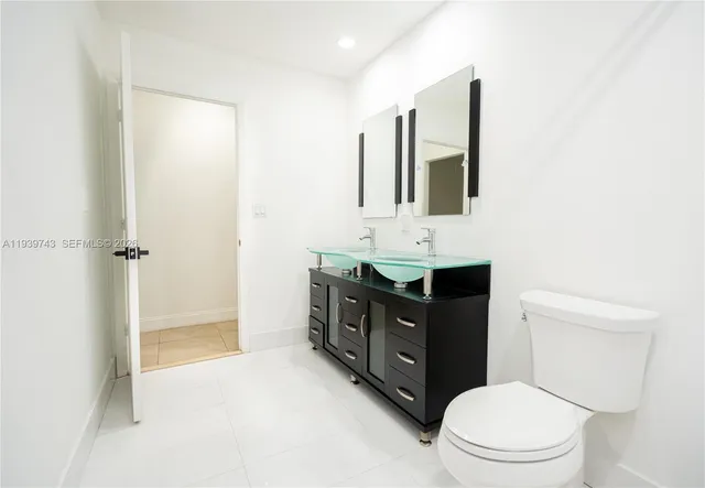 a bathroom with a toilet a sink a vanity and mirror