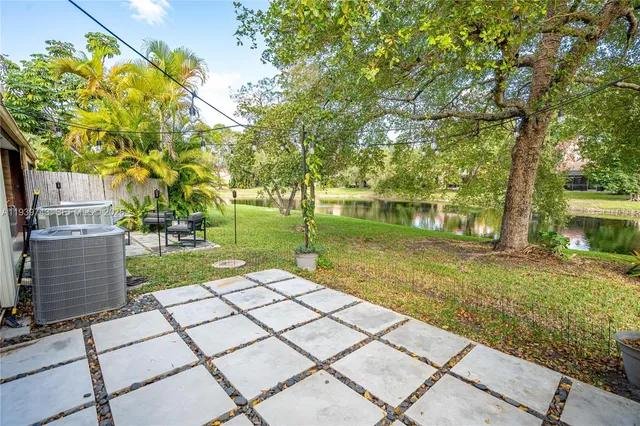 a view of a yard with plants and a bench