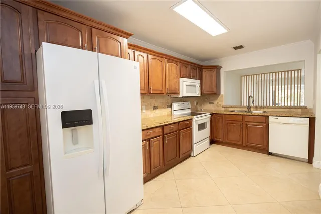 a kitchen with stainless steel appliances a refrigerator sink and white cabinets