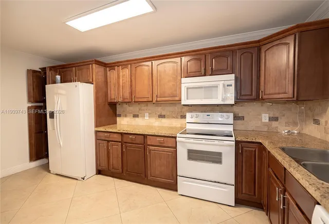 a kitchen with a refrigerator sink and cabinets