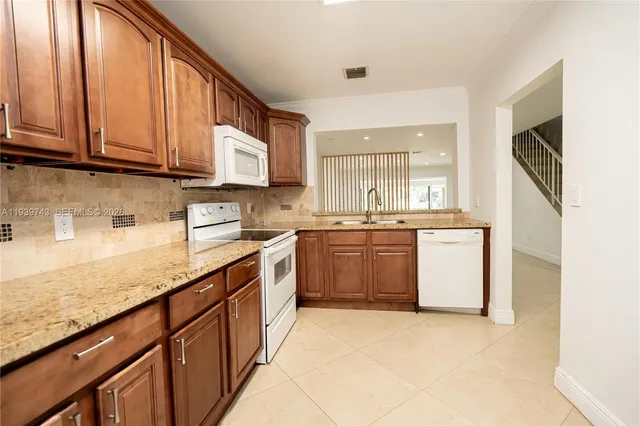 a kitchen with stainless steel appliances granite countertop a sink stove and cabinets