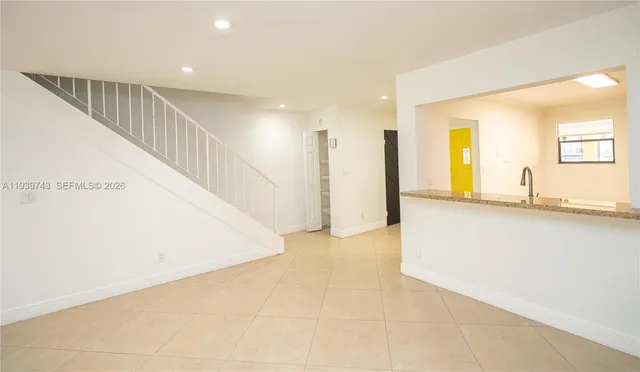 a view of a kitchen with a sink and a refrigerator