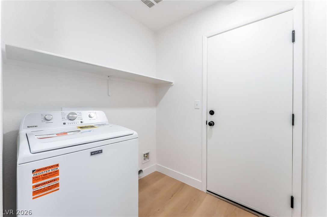 668 Rising Brook Drive Henderson, NV 89011 - Photo 17 of 22 A dedicated laundry space offers convenience with a washer and practical shelving.