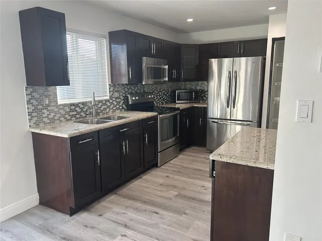 a kitchen with a refrigerator stove and sink