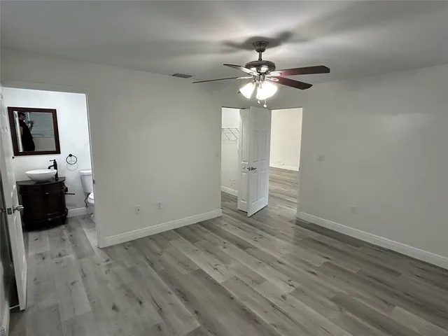 a view of an empty room with a window and wooden floor