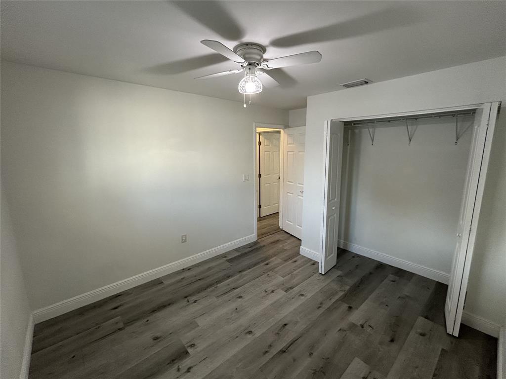 10420 Southwest 207th Street Cutler Bay, FL 33189 - Photo 10 of 12 an empty room with wooden floor and fan