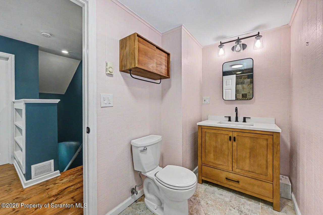 457 Craig Road Dalton, PA 18414 - Photo 85 of 114 a bathroom with a toilet a sink a mirror and vanity