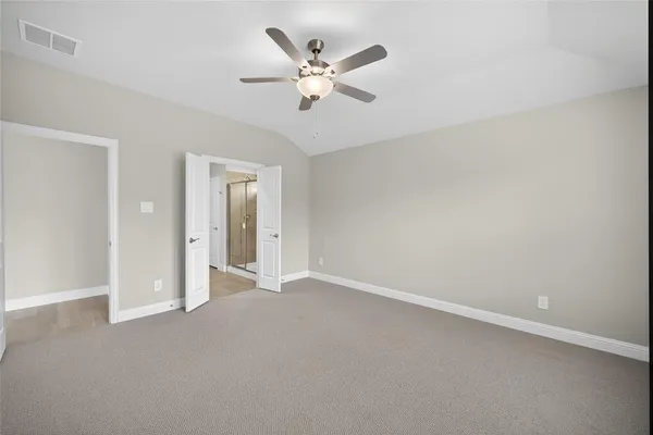 an empty room with closet and ceiling fan