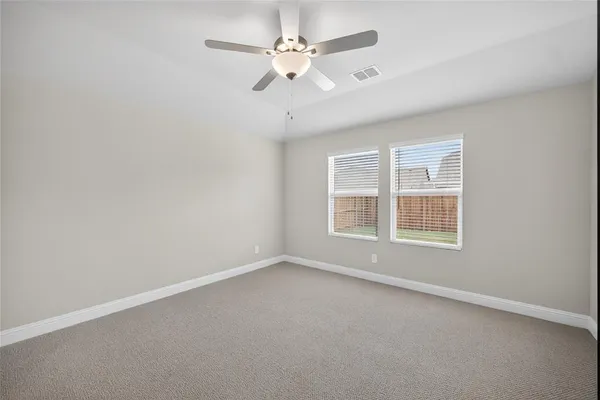an empty room with a window and a fan