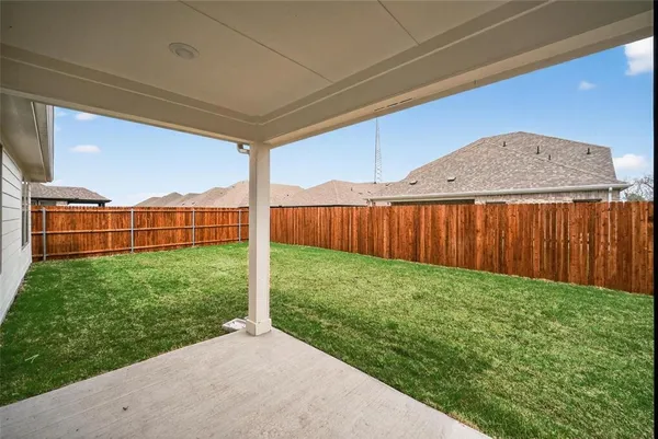 a view of a backyard with wooden fence