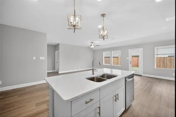 a kitchen with a sink a counter space and wooden floor