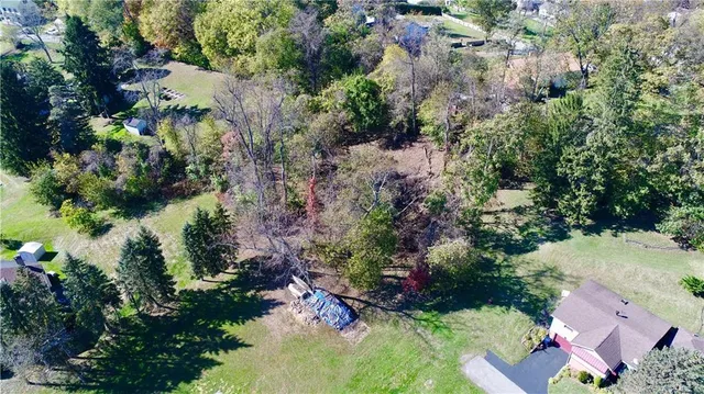 an aerial view of residential house with outdoor space and trees all around
