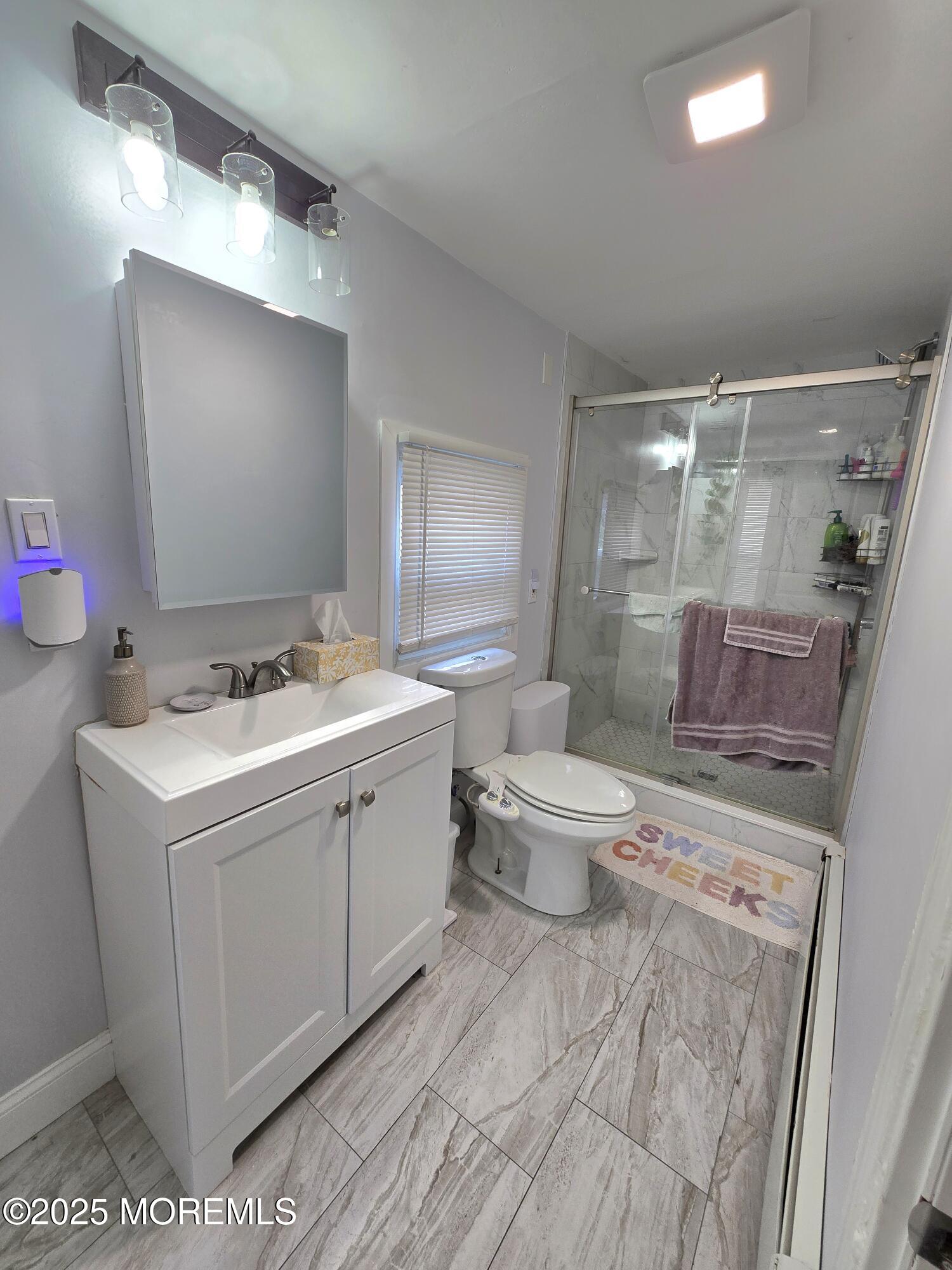 305 3rd Avenue, Unit 1 Asbury Park, NJ 07712 - Photo 6 of 13 a bathroom with a sink toilet double vanity and shower