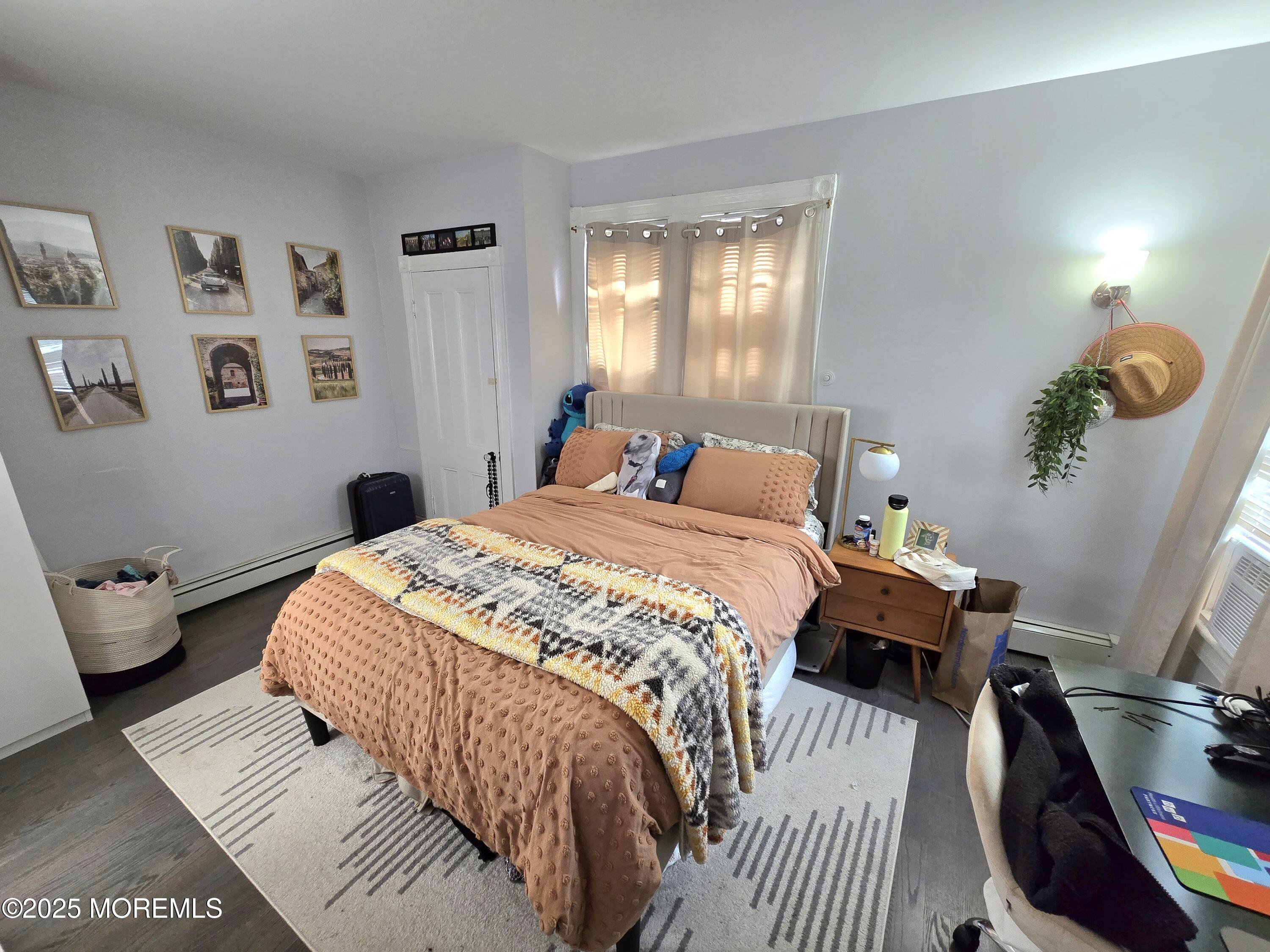 305 3rd Avenue, Unit 1 Asbury Park, NJ 07712 - Photo 9 of 13 a bedroom with a bed and wooden floor