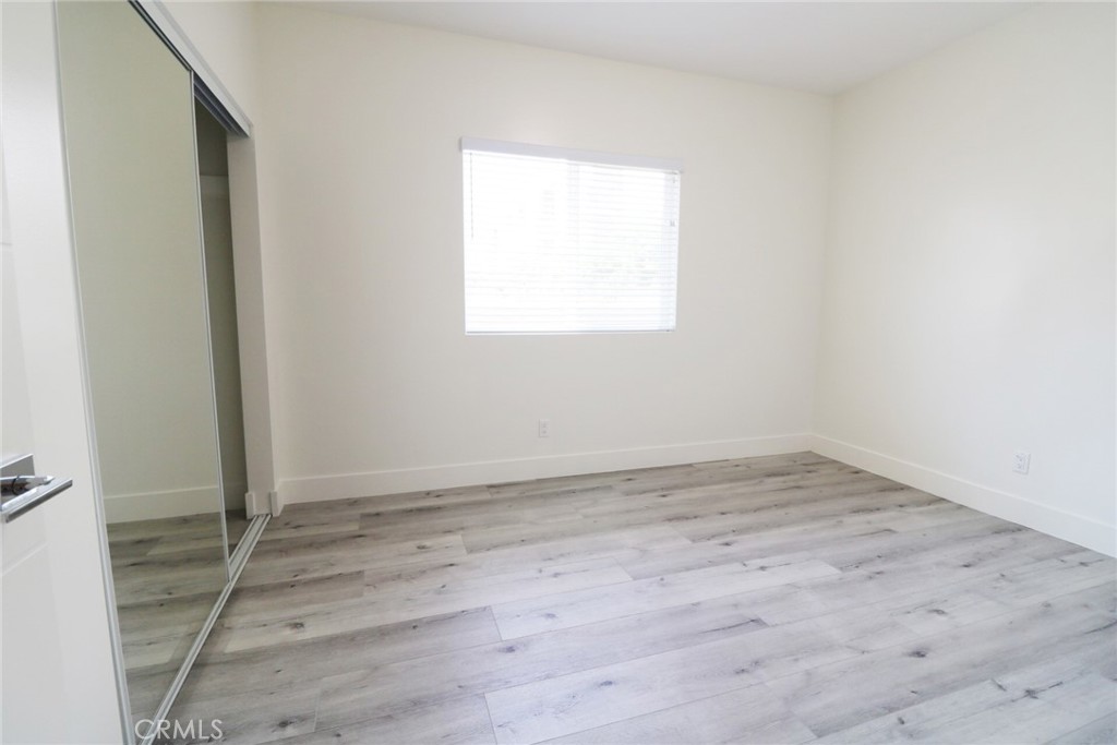 14254 Erwin Street Van Nuys, CA 91401 - Photo 13 of 18 an empty room with wooden floor and windows