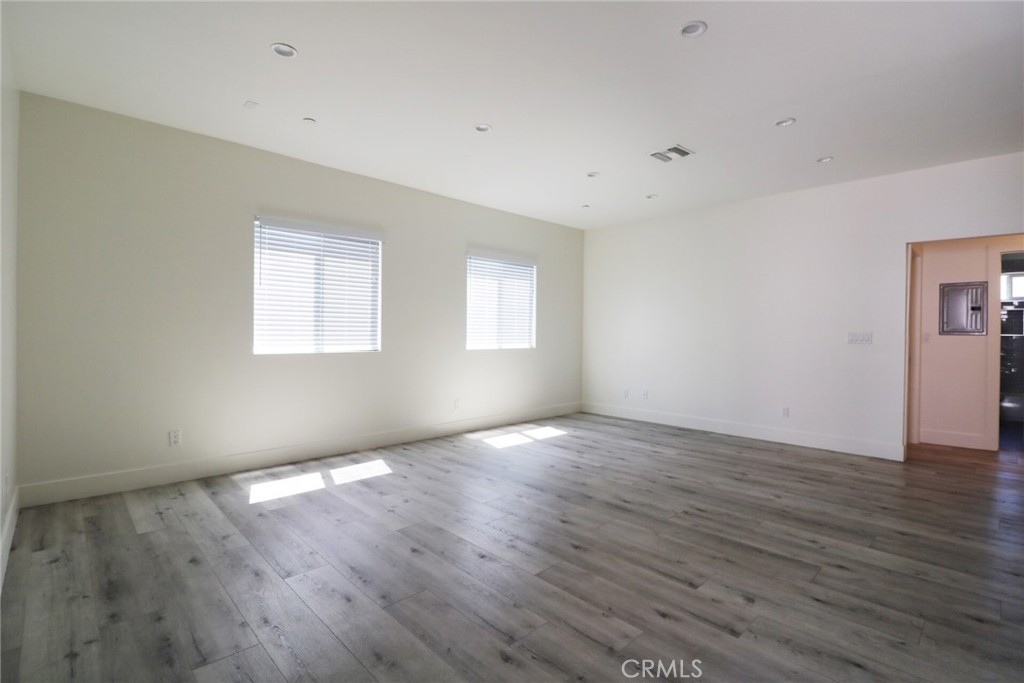 14254 Erwin Street Van Nuys, CA 91401 - Photo 5 of 18 an empty room with wooden floor and windows