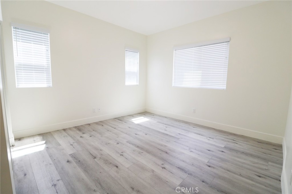 14254 Erwin Street Van Nuys, CA 91401 - Photo 9 of 18 an empty room with wooden floor and windows