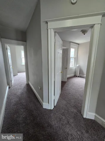 a view of a hallway with a livingroom and a chair