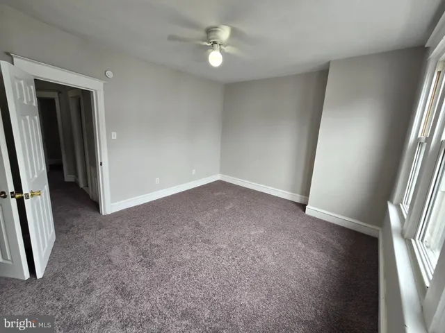 an empty room with a ceiling fan and a hardwood floor