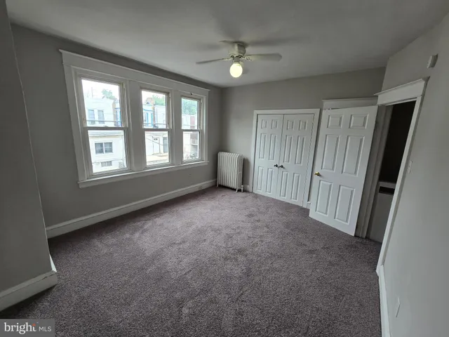 an empty room with a fireplace and windows