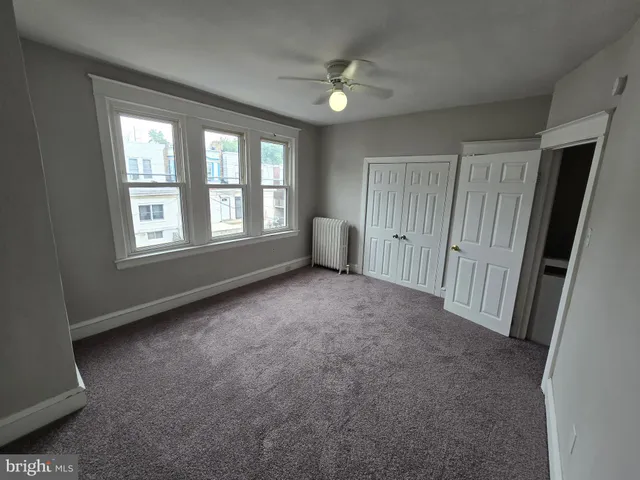 an empty room with windows and closet