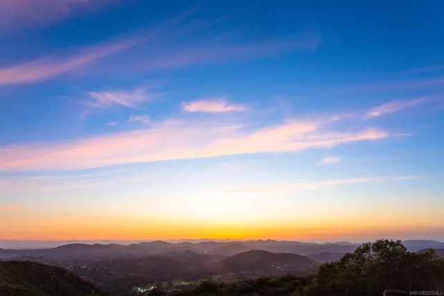 a view of a mountain with a field