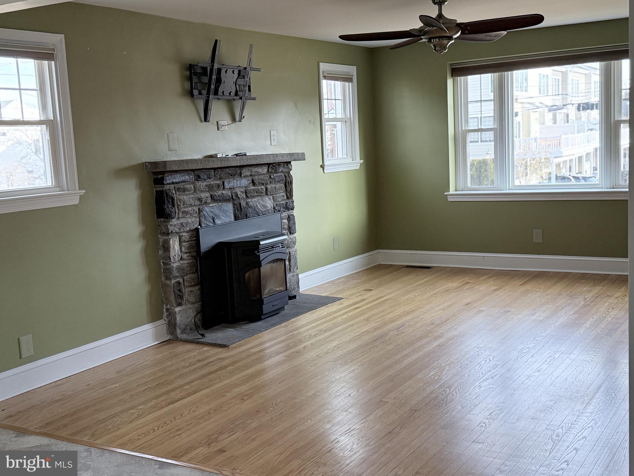 302 South Valley Forge Road Devon, PA 19333 - Photo 11 of 28 an empty room with wooden floor fireplace and windows
