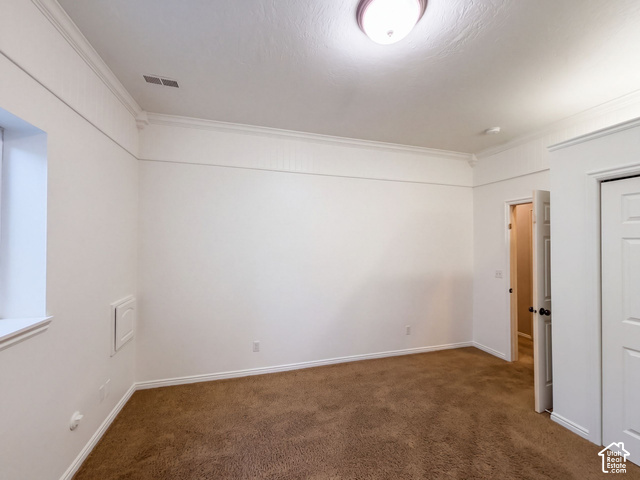 232 Bugle Way Providence, UT 84332 - Photo 17 of 36 Recessed ceiling light, crown molding, white trim, wall paneling, and brown carpet flooring
