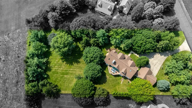 a front view of a house with a garden and trees