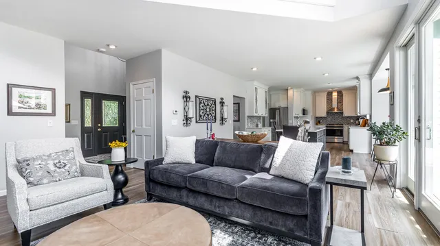 a bathroom with a granite countertop sink a large mirror a bathtub and next to a window