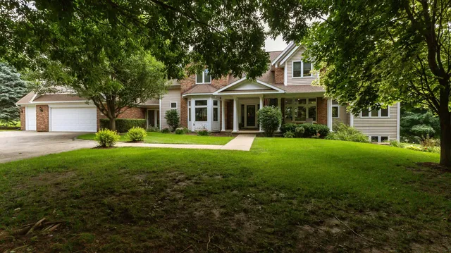 a view of a house with a yard and large tree