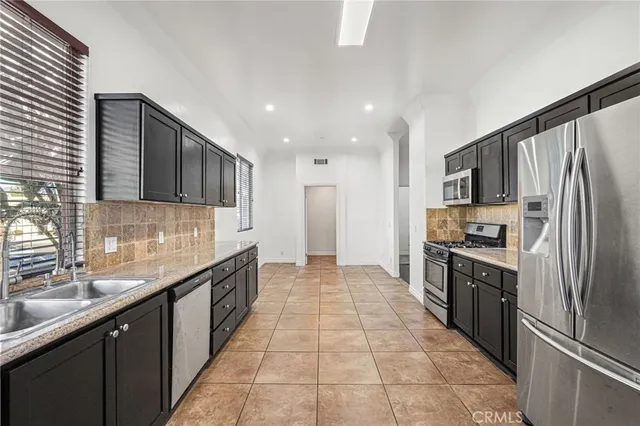 a kitchen with stainless steel appliances granite countertop a refrigerator and a sink