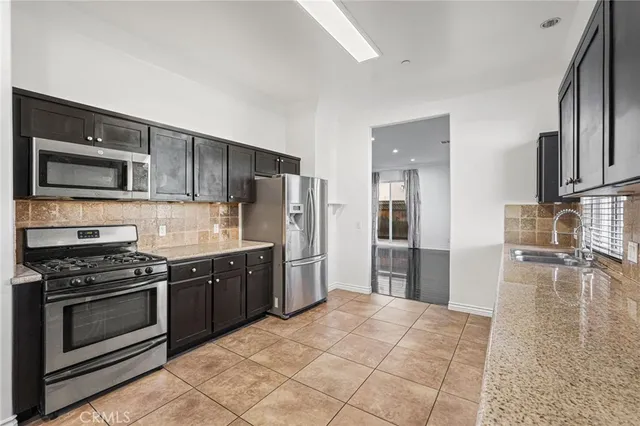 a kitchen with stainless steel appliances granite countertop a stove refrigerator and microwave