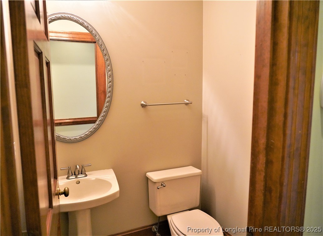 568 Broyhill Road Fayetteville, NC 28314 - Photo 16 of 37 a bathroom with a toilet a sink and mirror