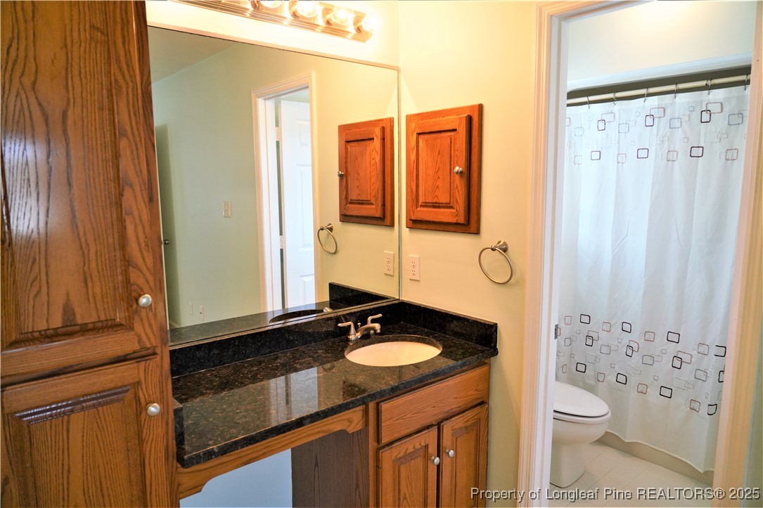 568 Broyhill Road Fayetteville, NC 28314 - Photo 25 of 37 a bathroom with a granite countertop sink and a mirror