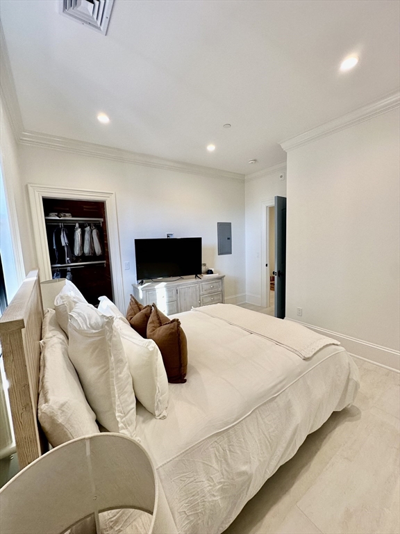 6 Douglas Street, Unit 1L Boston, MA 02127 - Photo 14 of 16 a bedroom with a bed and a flat screen tv