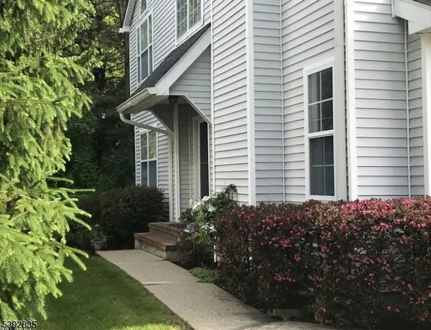 a view of a house with brick walls and a yard with plants