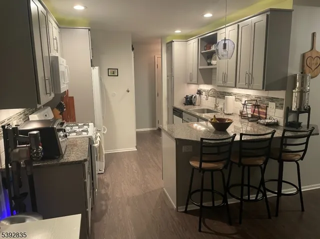 a kitchen with stainless steel appliances kitchen island granite countertop a table and chairs