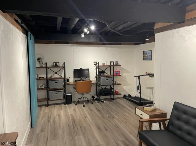 a view of a workspace with furniture and wooden floor