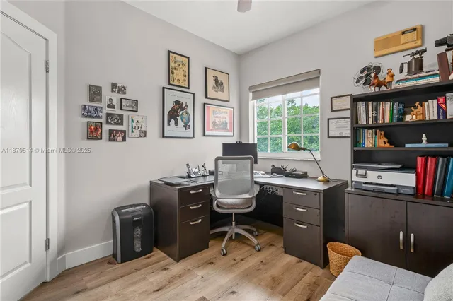 a view of a workspace with furniture and a window