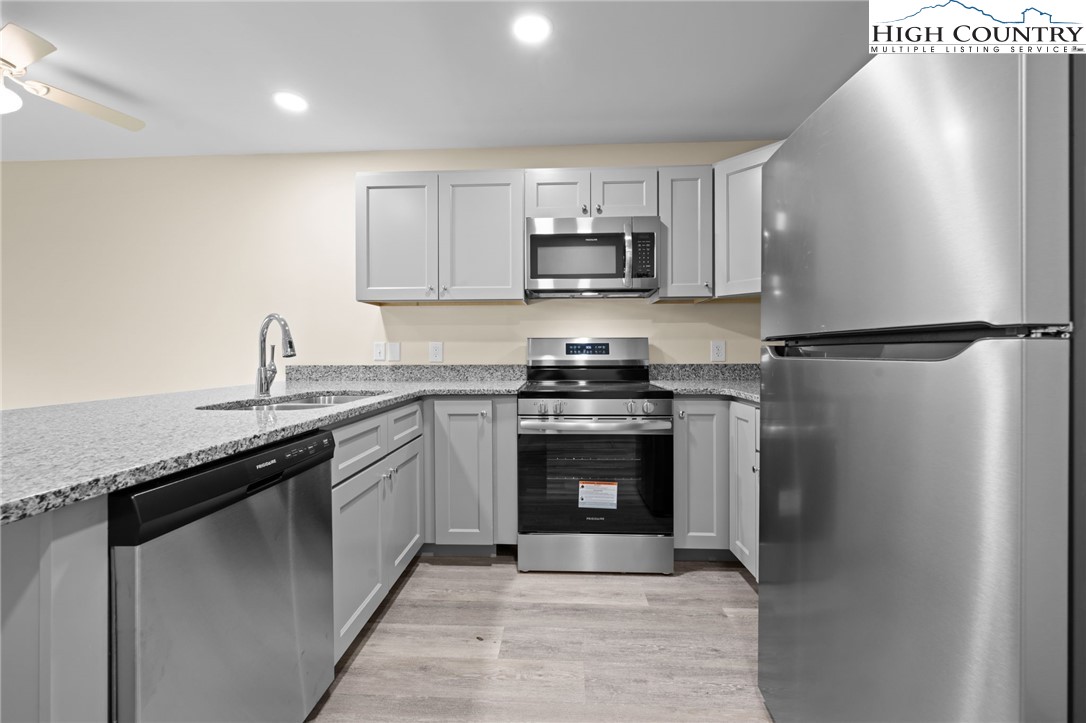 128 Zeb Street, Unit A101 Boone, NC 28607 - Photo 8 of 32 a kitchen with stainless steel appliances granite countertop a refrigerator sink and stove