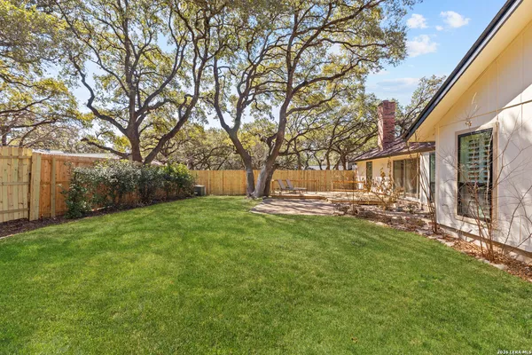 an aerial view of a house with a yard and large trees