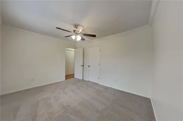 a view of an empty room with a chandelier fan