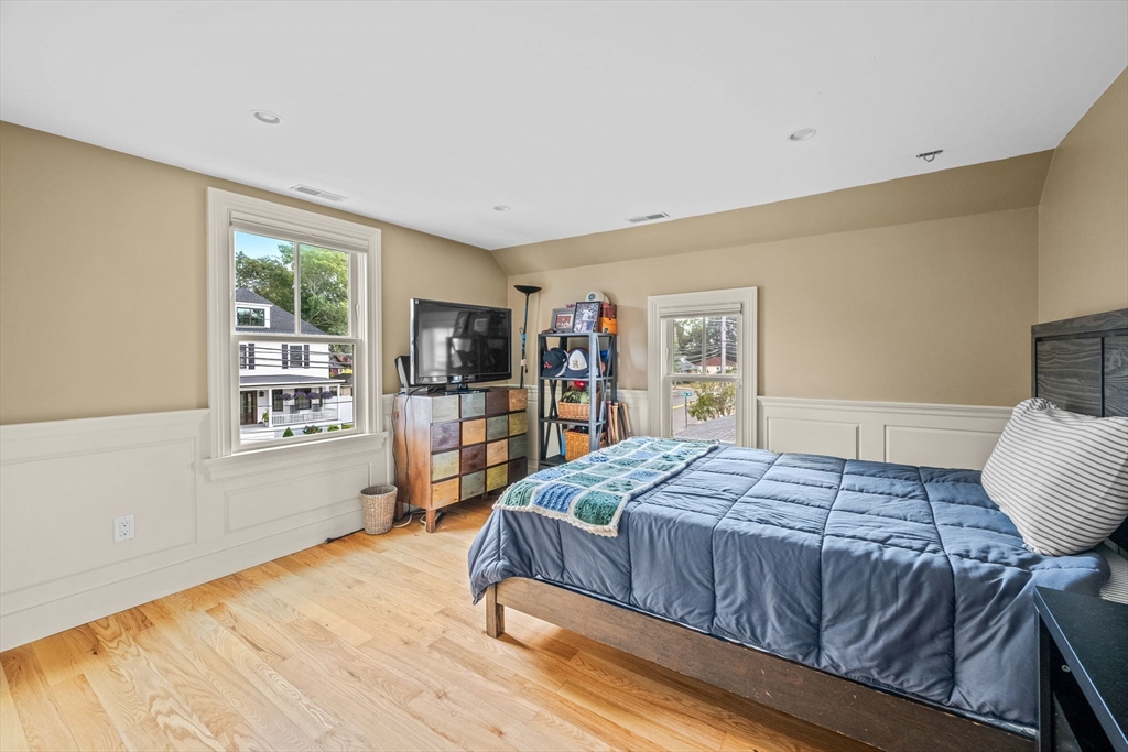 90 Dodge Street Beverly, MA 01915 - Photo 18 of 37 a bedroom with a large bed and a wooden floor