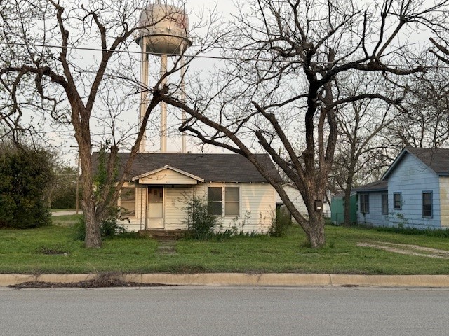 a front view of a house with a garden and trees