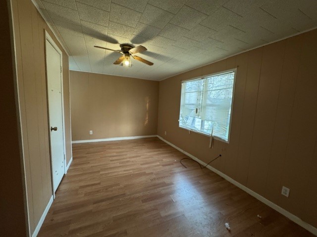 501 Reagan Street South West, TX 76691 - Photo 4 of 12 an empty room with wooden floor fan and windows