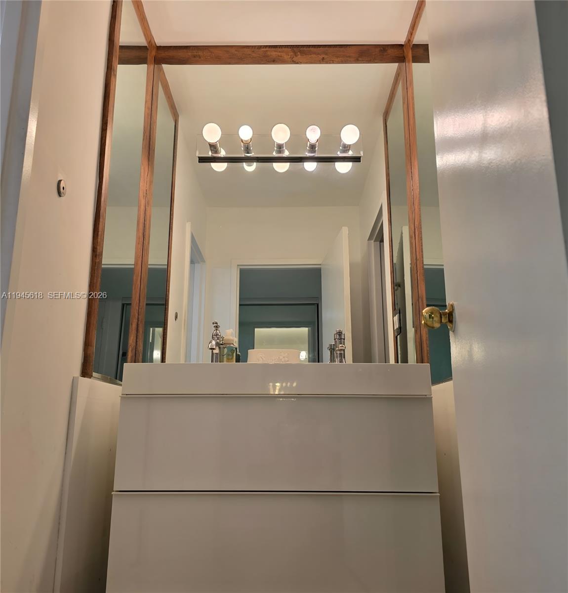 100 Lincoln Road, Unit 503 Miami Beach, FL 33139 - Photo 12 of 25 a view of a living room with a mirror and a chandelier